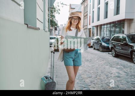 Junge Reisende auf der Suche nach der richtigen Richtung auf einem Stadtplan auf einer Stadtstraße, Reisen in Europa, Freiheit und aktiven Lebensstil Stockfoto