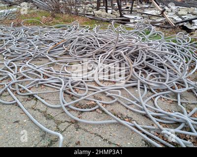 Wellrohre für elektrische Verdrahtung liegen in einem Haufen auf dem Boden. Stockfoto