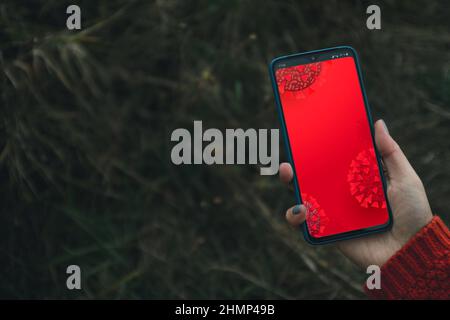 Aktuelle Nachrichten Omicron COVID-19 Variant Poster, Coronavirus auf dem Bildschirm Smartphone in der Hand. Stockfoto