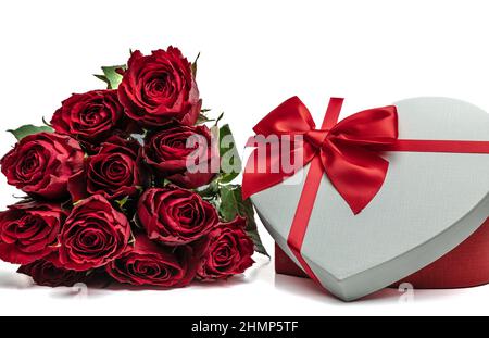 Rote Rosen und eine herzförmige Geschenkbox Stockfoto