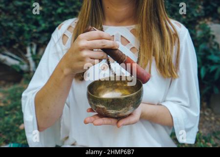 Unerkannte Frau spielt tibetische Klangschale Stockfoto