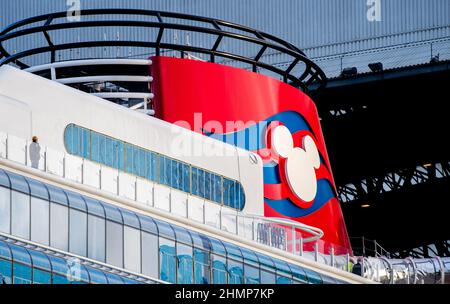 Papenburg, Deutschland. 11th. Februar 2022. Das Disney Cruise Line-Logo auf einem Schornstein leuchtet in der Sonne, als das Kreuzschiff „Disney Wish“ aus dem Baudock der Meyer Werft gezogen wird. Der Neubau soll in diesem Jahr an Disney Cruise Line ausgeliefert werden. Quelle: Hauke-Christian Dittrich/dpa/Alamy Live News Stockfoto