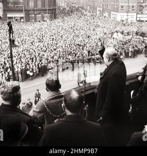 Winston Churchill 1874-1965 gibt sein berühmtes „V for Victory“-Zeichen, während er sich an Menschenmengen vom Balkon des Rathauses in Sheffield wendet. Stockfoto