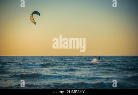 Surfer macht, was er am Abend liebt Stockfoto