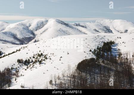 Winter idyllisch auf Bergort Zlatibor, Serbien, Europa und Straße in ländlicher Landschaft. Tornik Ski-Zentrum in der Ferne Stockfoto