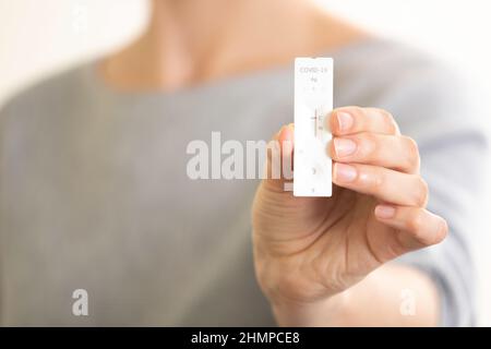 Frau, die das Schnellantigen-Diagnosetestgerät Covid-19 zeigte. Nahaufnahme der Hand einer Frau mit negativem Testergebnis auf dem Teststreifen Stockfoto