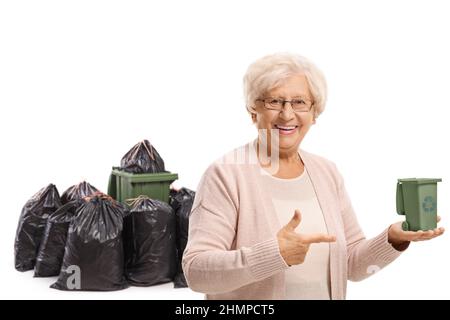 Ältere Frau, die einen kleinen Papierkorb an der Hand hält und isoliert auf weißen Hintergrund zeigt Stockfoto