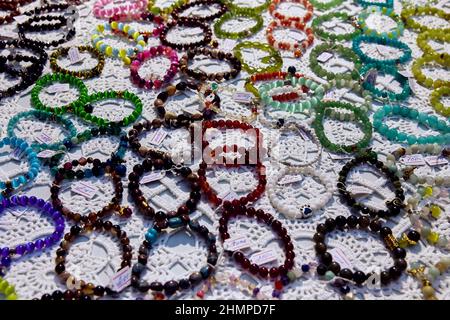 Muster von Schmuck aus Handarmbändern in verschiedenen Farben von Perlen auf weißem Hintergrund in Odessa Ukraine. Ukrainische Volkskunst Stockfoto