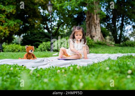 Kleines Mädchen spielt mit Buch für Kinder Stockfoto