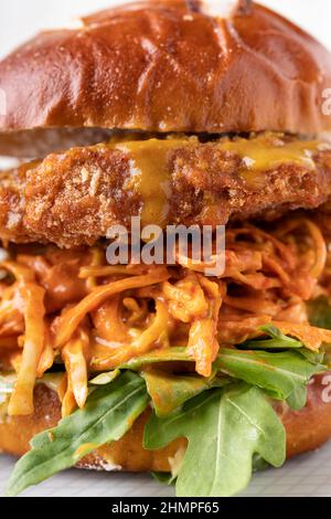 Asiatische Fusion veganes weiches Brötchen mit fleischfreiem Kichererbsen-Burger, saftiger Kohlgarnierung und grünen Rucola-Blättern Stockfoto