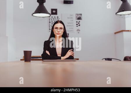 Brunette in einem Business-Anzug beim Interview sitzt am Tisch ist besorgt Stockfoto