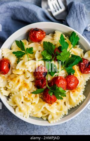 Blick von oben auf eine Schüssel mit Farfalle-Pasta mit gerösteten Tomaten und Koriander Stockfoto