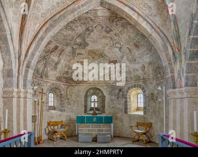 Der feierliche Chor in der Skurup-Kirche mit einem Steinaltar und einem großen Wandgemälde mit Christus in Majestät, dem pantokrator, Skurup, Schweden, 16. Juli, 2021 Stockfoto