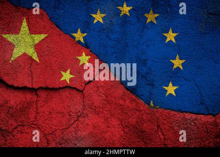 Vollformatfoto einer verwitterten Flaggen Chinas und der Europäischen Union (EU) auf einer rissigen Wand. Stockfoto