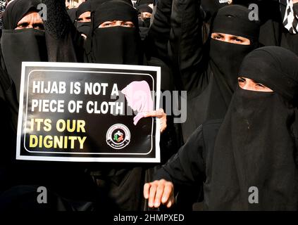 Mumbai, Indien. 11th. Februar 2022. Muslimische Frauen halten während der Demonstration ein Plakat mit der Aufschrift „Hijab ist kein Stück Stoff, seine würde“ an der Mira Road (Bezirk Thane). Im College in Karnataka (Bundesstaat Südindien) brach eine Hijab-Reihe über Studenten aus, die an der Hochschule religiöse Kleidung trugen. Der hohe Gerichtshof von Karnataka ordnete an, dass Studenten keine religiösen Kleider an Hochschulen tragen sollten. Die Angelegenheit wird nun am 14th. Februar 2022 gehört. Kredit: SOPA Images Limited/Alamy Live Nachrichten Stockfoto