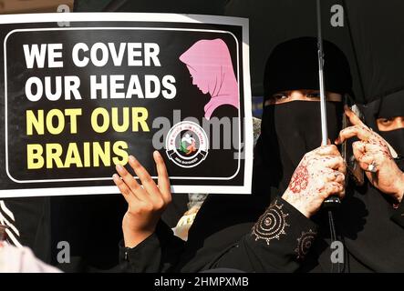 Mumbai, Indien. 11th. Februar 2022. Eine muslimische Frau hält während der Demonstration ein Plakat mit der Aufschrift „Wir bedecken unsere Köpfe und nicht die Gehirne“ an der Mira Road (Bezirk Thane). Im College in Karnataka (Bundesstaat Südindien) brach eine Hijab-Reihe über Studenten aus, die an der Hochschule religiöse Kleidung trugen. Der hohe Gerichtshof von Karnataka ordnete an, dass Studenten keine religiösen Kleider an Hochschulen tragen sollten. Die Angelegenheit wird nun am 14th. Februar 2022 gehört. (Foto von Ashish Vaishnav/SOPA Images/Sipa USA) Quelle: SIPA USA/Alamy Live News Stockfoto