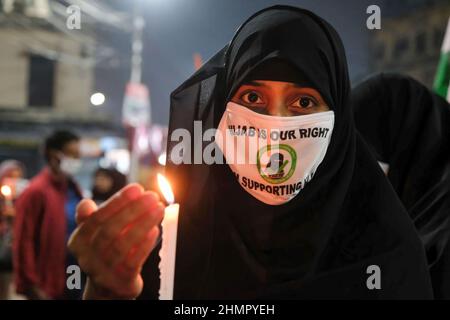 Kalkutta, Indien. 11th. Februar 2022. Eine burqa bekleidete muslimische Frau hält während einer Demonstration an einer staatlich geführten Hochschule im indischen Bundesstaat Karnataka eine brennende Kerze in der Hand, wo muslimischen Schülern gesagt wurde, dass sie keine Hijabs auf dem Institutsgelände tragen sollten. (Foto von Dipayan Bose/SOPA Images/Sipa USA) Quelle: SIPA USA/Alamy Live News Stockfoto
