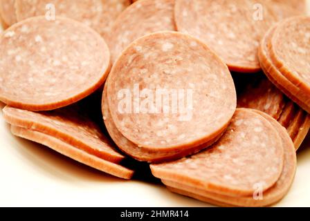 Nahaufnahme von harten Salami-Scheiben in einer weißen Schüssel Stockfoto