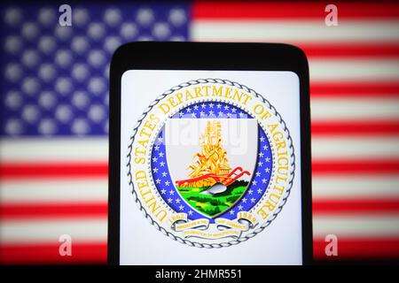 Ukraine. 11th. Februar 2022. In dieser Abbildung ist das Siegel des US-Landwirtschaftsministeriums (USDA) auf einem Smartphone-Bildschirm und die US-Flagge im Hintergrund zu sehen. (Bild: © Pavlo Gonchar/SOPA Images via ZUMA Press Wire) Bild: ZUMA Press, Inc./Alamy Live News Stockfoto