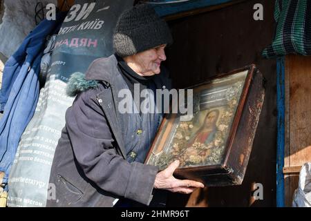 Zaitsewe, Donezk, Ukraine. 5th. Februar 2022. Sofiya (Name griechischer Herkunft, was "Weisheit" bedeutet) im Alter von 85 Jahren sah sich die orthodoxe Ikone an, die ihr während der Beschuss-Zeiten am Stadtrand von Zaitseve das Leben rettete.US-Präsident Joe Biden hat alle in der Ukraine verbliebenen amerikanischen Bürger aufgefordert, das Land sofort zu verlassen. Unter Berufung auf die zunehmenden Bedrohungen der russischen Militäraktion. Er sagte, dass er keine Truppen entsenden würde, um die Amerikaner zu retten, wenn Moskau die Ukraine einmarschiert. Der Kreml sagt, dass er "rote Linien" durchsetzen will, um sicherzustellen, dass sein ehemaliger sowjetischer Nachbar nicht der NATO Beitritt (Foto: © Andriy Andr Stockfoto