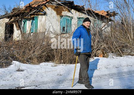 Zaitsewe, Donezk, Ukraine. 5th. Februar 2022. Ein alter Mann, der in der Nähe des 120 Jahre zerstörten, verlassenen Hauses am Stadtrand von Zaitseve stehen sah.US-Präsident Joe Biden hat alle in der Ukraine verbliebenen amerikanischen Bürger aufgefordert, das Land sofort zu verlassen, unter Berufung auf die zunehmende Bedrohung durch russische Militäraktion. Er sagte, dass er keine Truppen entsenden würde, um die Amerikaner zu retten, wenn Moskau die Ukraine einmarschiert. Der Kreml sagt, er wolle "rote Linien" durchsetzen, um sicherzustellen, dass sein ehemaliger sowjetischer Nachbar nicht der NATO Beitritt (Foto: © Andriy Andriyenko/SOPA Images via ZUMA Press Wire) Stockfoto