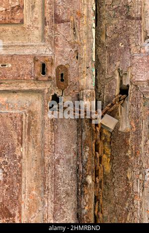 Alte Holztür mit rostiger Kette und Schloss Stockfoto