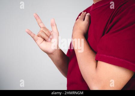 Zeichen der Selbstliebe. Umarmen Sie sich selbst und positives Denken. Der Mann mit rotem Hemd in mittlerer Nahaufnahme. Platz für Nachrichten, Wörter und Texte kopieren. Stockfoto