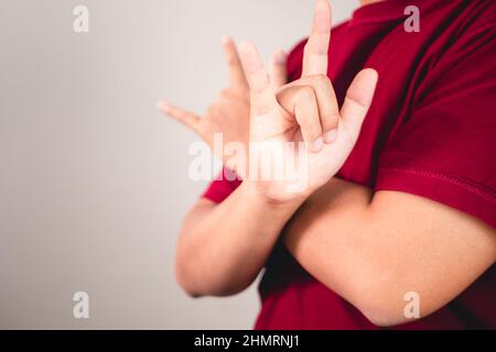 Zeichen der Selbstliebe. Umarmen Sie sich selbst und positives Denken. Der Mann mit rotem Hemd in mittlerer Nahaufnahme. Platz für Nachrichten, Wörter und Texte kopieren. Stockfoto