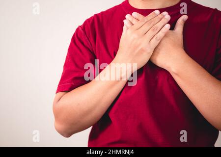 Zeichen der Selbstliebe. Umarmen Sie sich selbst und positives Denken. Der Mann mit rotem Hemd in mittlerer Nahaufnahme. Platz für Nachrichten, Wörter und Texte kopieren. Stockfoto