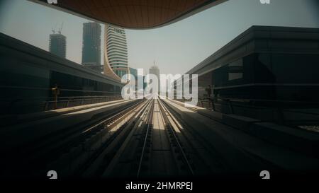 Metro In Dubai, Vereinigte Arabische Emirate. FPV POV bei Fast Speed Drive Motion. Fahrerlose U-Bahn in verschwommener Form. Futuristische Skyline der Vereinigten Arabischen Emirate. Langzeitbelichtung Stockfoto