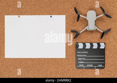 Korkhintergrund mit einem großen weißen Papier, einer kleinen Drohne und einem Klappbrett Stockfoto