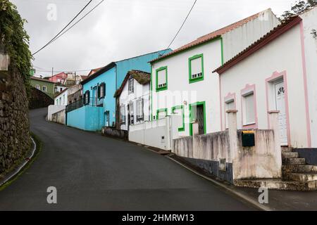 Schmale steile Straße mit bunten Häusern in einem kleinen Ort auf der Terceira Insel Azoren, Portgal Stockfoto
