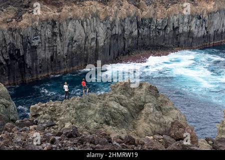 Mutter und Sohn stehen auf erstaunlichen Felsformationen in Baia da Agualva, Terceira Island, Azoren, Portugal Stockfoto