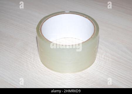 Rolle von Scotch Tape auf einem Holztisch aus nächster Nähe Stockfoto
