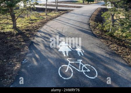 Weiße Straßenmarkierungen für Fußgänger und Radfahrer.die Wander- und Radwege im Park. Infrastruktur für Wandern und körperliche Aktivität Stockfoto
