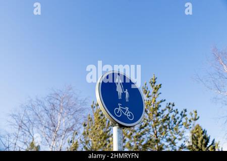 Blaue Fußgängerüberführung und Fahrradstraßenschild.Radweg und Gehweg für Wanderer. Infrastruktur für Wandern und körperliche Aktivität im Park Stockfoto