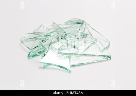 Glassplitter zerbrochener Fensterhaufen auf weißgrauem Hintergrund Stockfoto