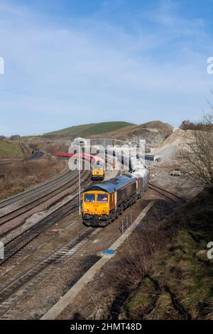 Dove Holes Quarry, Derbyshire. GB Railfreight Lok der Baureihe 66 66786 Verladen eines Zuschlagstoffzuges Trichter der Baureihe 56 56301, die zurückfahren. Stockfoto