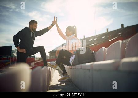Motiviertes, sportliches Paar, das nach dem Training zusammenhängt Stockfoto
