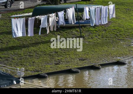 Wäscheleine mit Trockenwäsche vor Booten am Ufer der Trave in der Altstadt der Hansestadt Lübeck in Deutschland, Kopierraum, Stockfoto