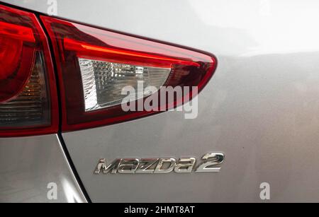 Die Rückleuchte und das Typenschild auf dem Kofferraum eines Mazda2 Auto Stockfoto
