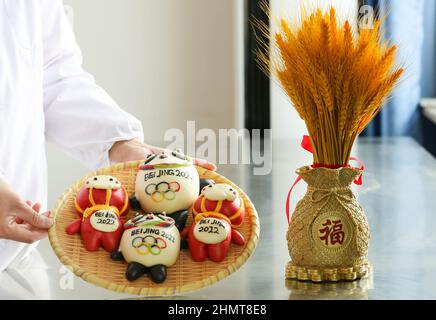 ZOUPING, CHINA - 12. FEBRUAR 2022 - die Bäcker machen Dampfbrötchen in der Form von Bing Dwen Dwen und Xue Rong Rong, den Maskottchen des Olympischen Winterspiels in Peking Stockfoto