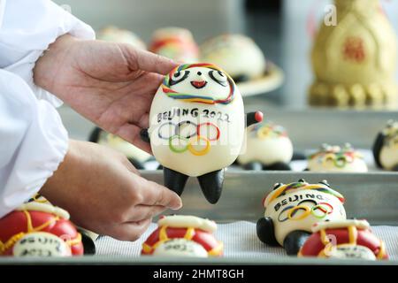 ZOUPING, CHINA - 12. FEBRUAR 2022 - Ein Konditor stellt in Z Dampfbrötchen in Form von Bing Dwen Dwen, dem Maskottchen der Olympischen Winterspiele in Peking, her Stockfoto