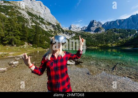 Ein Reisender mit Virtual-Reality-Brille. Das Konzept des virtuellen Reisens um die Welt. Im Hintergrund Schloss Neuschwanstein. Technologie der Zukunft Stockfoto