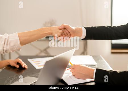 Nahaufnahme des Händebehackens von Mann und Frau, die Geschäftspartner sind. Dokumente mit unscharfem Hintergrund. Stock Foto Stockfoto