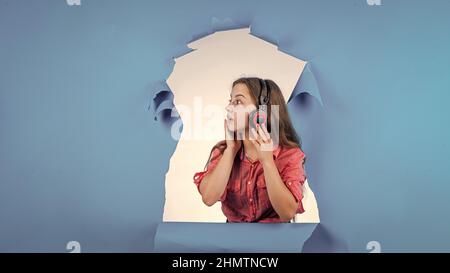 Teen Mädchen hören Musik in Kopfhörern. Glückliche Kindheit. Hübsches Kind auf Studio-Hintergrund. Stockfoto