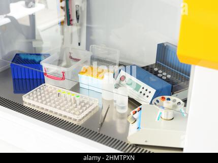 Arbeitsplatz eines Arztes in einem PCR-Labor - Dispenser, Behälter mit Reagenzgläsern Stockfoto