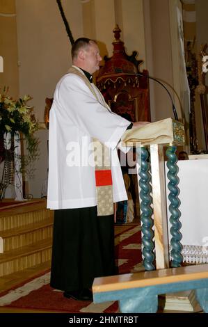 Wieleń Zaobrzański, Polen, Polen, Polska; Ein Priester in einer Soutane und Überdecke predigt von einer kleinen Kanzel. Priester in soutane und Chorhemd predigt. Stockfoto