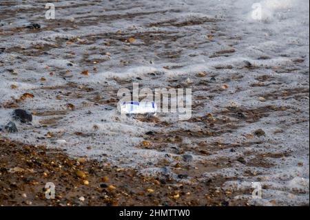 Ausrangierte gebrauchte Dose Energy Drink, die an einem sandigen Strand von Norfolk gewaschen wurde Stockfoto