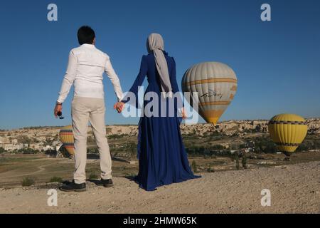 Das Paar reist um die Welt. Glückliches und liebevolles Paar unter Ballons in der Türkei. Verheiratetes Paar im Urlaub. Touristen in Kappadokien. Mann und Frau ruhen sich aus Stockfoto